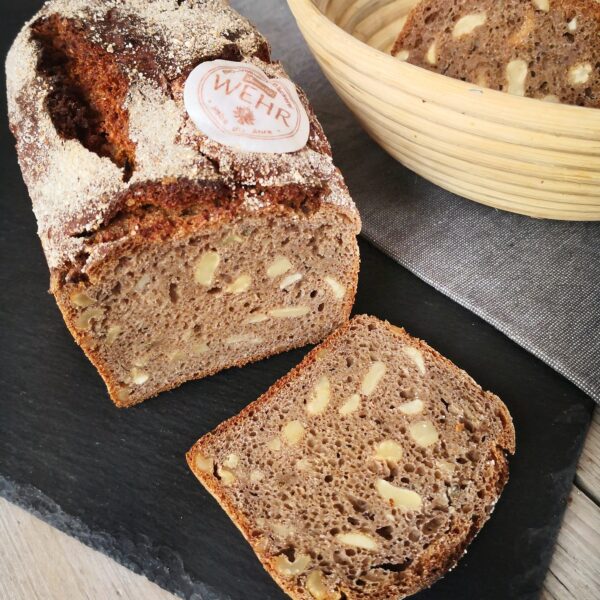 Vollkornbrot mit Cashewkernen angerichtet auf einer Schieferplatte mit Korb im Hintergrund; HofladenBOX