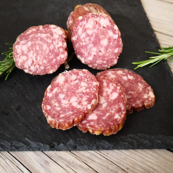 Salami aufgeschnitten auf einer Schieferplatte und mit Kräutern garniert; Salami mit Parmesan; HofladenBOX